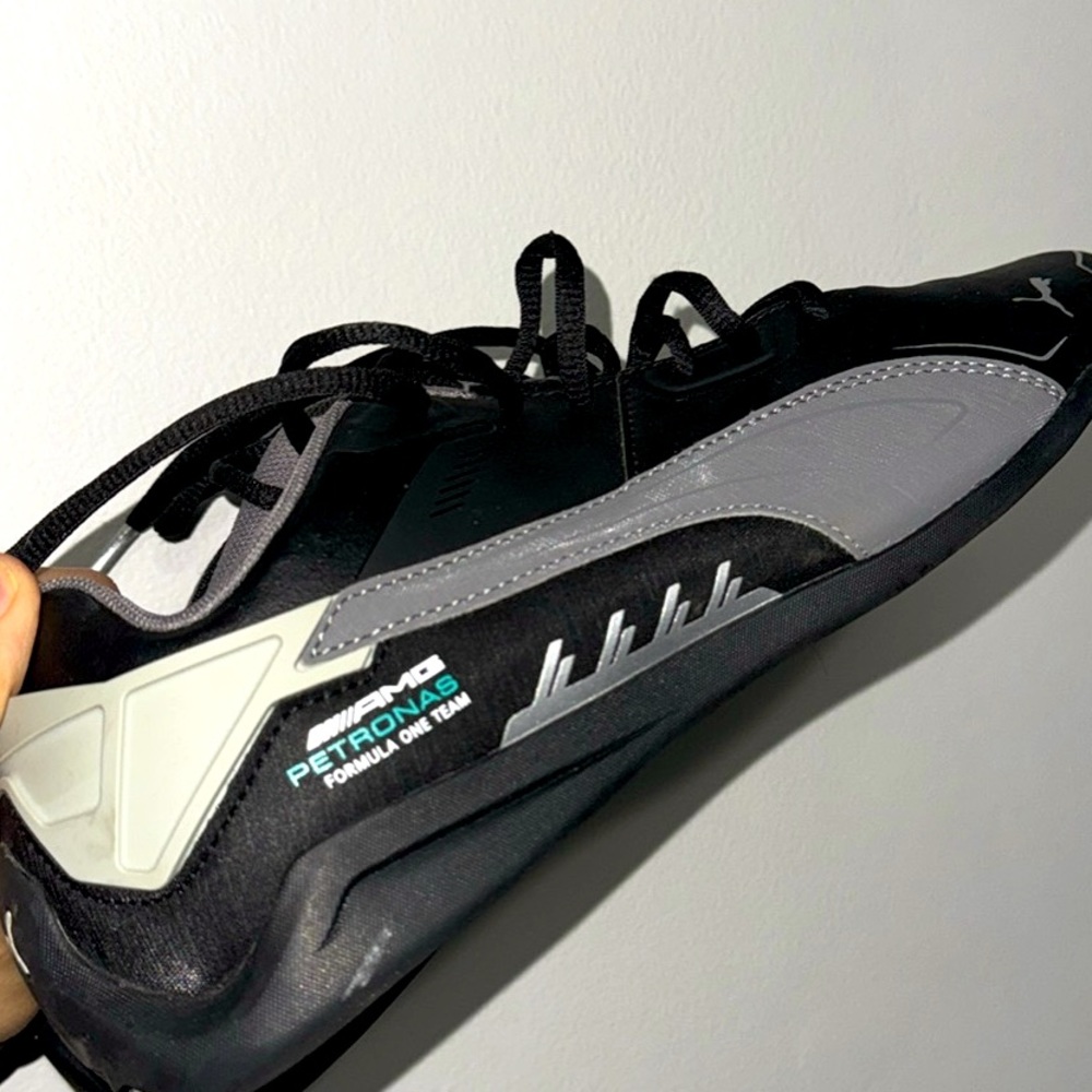 Black colour puma shoes of mecedes Amg series.